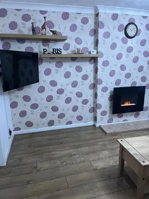 a living room with a fireplace and a tv at Princess Wigan House in Wigan