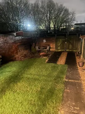 a garden at night with a table and a bench at Princess Wigan House in Wigan