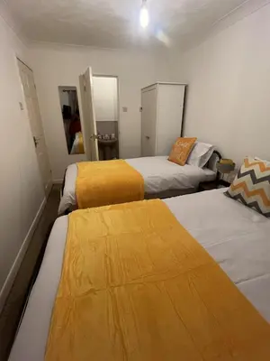 a bedroom with two beds and two mirrors at Princess Wigan House in Wigan