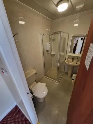 a bathroom with a toilet and a shower and a sink at The Arabella in Blackpool