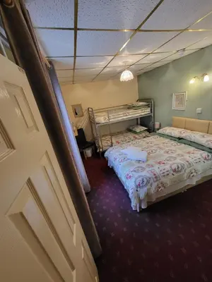 a room with two beds in a room with a door at The Arabella in Blackpool