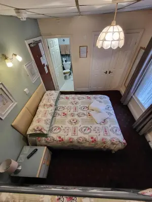 a small bedroom with a bed and a mirror at The Arabella in Blackpool