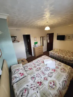 a hotel room with two beds and a television at The Arabella in Blackpool