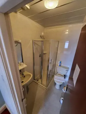 a bathroom with a shower and a toilet and a sink at The Arabella in Blackpool