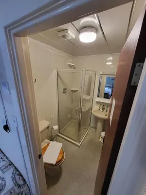 a bathroom with a shower and a toilet and a sink at The Arabella in Blackpool