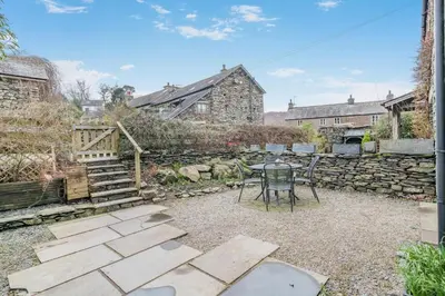 a patio with a table and a stone wall at 2 Bed in Ulverston oc-sz013 in Haverthwaite
