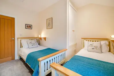 two twin beds in a room with a door at 2 Bed in Ulverston oc-sz013 in Haverthwaite