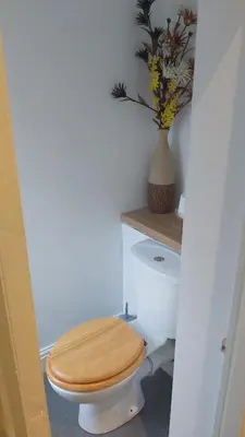 a bathroom with a toilet with a wooden toilet seat at Blackpool Central Beach Apartments in Blackpool