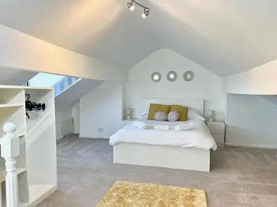 a white bedroom with a bed and a vaulted ceiling at Cosy 4 bedroom house in Marshside
