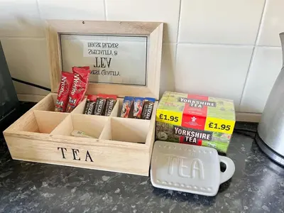 a wooden crate filled with books and a cup of tea at Cosy 4 bedroom house in Marshside