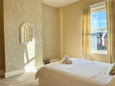 a bedroom with a white bed and a window at Cosy 4 bedroom house in Marshside