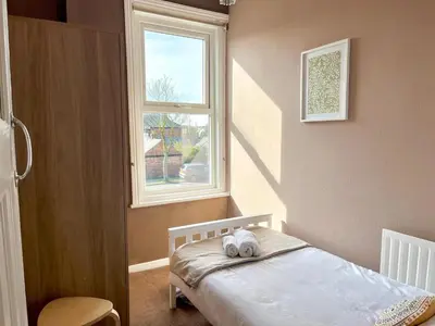 a small bedroom with a bed and a window at Cosy 4 bedroom house in Marshside