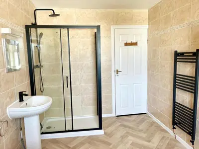 a bathroom with a shower and a toilet and a sink at Cosy 4 bedroom house in Marshside