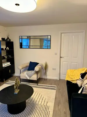 a living room with a couch and a table at Mo Apartment in Accrington