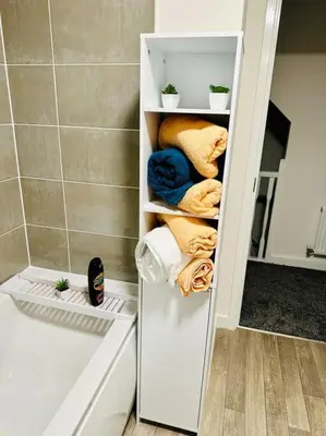 a white cabinet in a bathroom with towels at Mo Apartment in Accrington