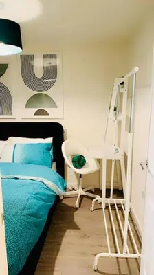 a bedroom with a bed and a desk and a chair at Mo Apartment in Accrington