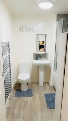 a bathroom with a toilet and a sink at Mo Apartment in Accrington