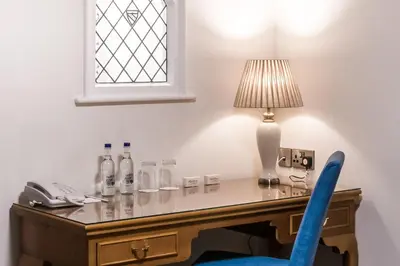 a desk with a lamp and a blue chair at Last Drop Village Hotel & Spa in Bolton