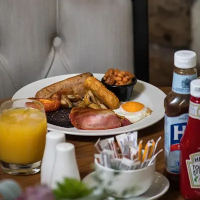 a plate of breakfast food with eggs sausage and toast at Last Drop Village Hotel & Spa in Bolton