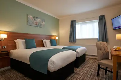 a hotel room with two beds and a desk at Last Drop Village Hotel & Spa in Bolton
