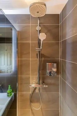 a shower with a shower head in a bathroom at Spacious 3-bed Home - Nature Reserve Retreat in Ince-in-Makerfield