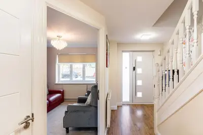 a living room with a couch and a stairway at Spacious 3-bed Home - Nature Reserve Retreat in Ince-in-Makerfield