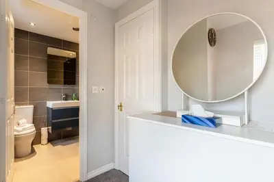 a bathroom with a mirror and a sink and a toilet at Spacious 3-bed Home - Nature Reserve Retreat in Ince-in-Makerfield