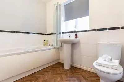 a bathroom with a toilet and a sink and a tub at Spacious 3-bed Home - Nature Reserve Retreat in Ince-in-Makerfield