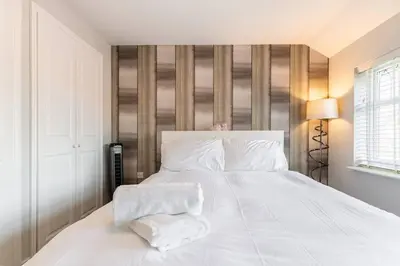 a white bed with two towels on top of it at Spacious 3-bed Home - Nature Reserve Retreat in Ince-in-Makerfield
