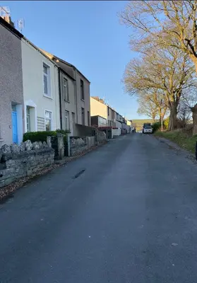 an empty street with houses and a car on the road at Outskirts of Ulverston, entire Cottage - sleeps 4 in Ulverston