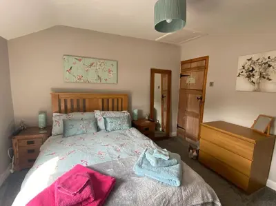 a bedroom with a bed and a wooden dresser and a dresser at Outskirts of Ulverston, entire Cottage - sleeps 4 in Ulverston