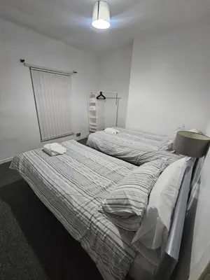 a bedroom with two beds and a window at Your Happy Place-2 Bedroom House in Liverpool