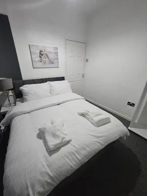 a bedroom with a white bed with towels on it at Your Happy Place-2 Bedroom House in Liverpool