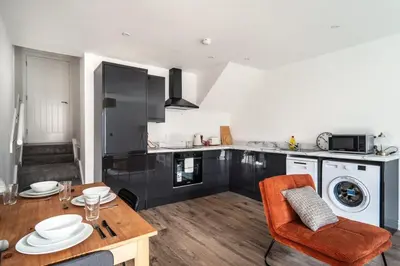 a kitchen with a table and a dining room at Modern 2 Bed Apartment in Waterloo Liverpool in Liverpool