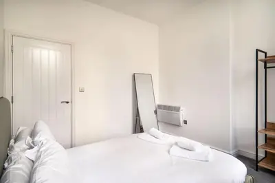 a white bed with two towels on top of it at Modern 2 Bed Apartment in Waterloo Liverpool in Liverpool