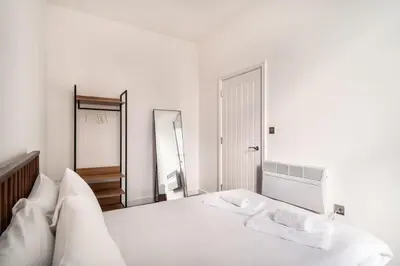 a white bedroom with a bed with two towels on it at Modern 2 Bed Apartment in Waterloo Liverpool in Liverpool
