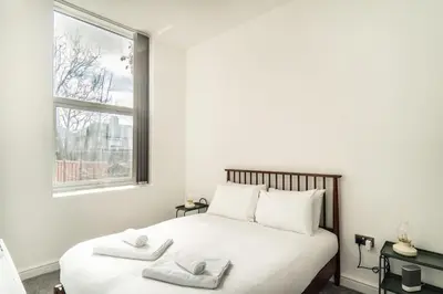 a bedroom with a bed with two towels on it at Modern 2 Bed Apartment in Waterloo Liverpool in Liverpool