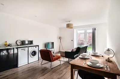a kitchen and living room with a table and chairs at Modern 2 Bed Apartment in Waterloo Liverpool in Liverpool