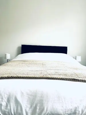 a white bed with white sheets and two lamps at Valley Road, Anfield LFC in Liverpool