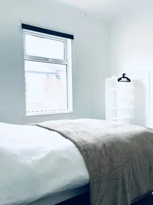 a white bedroom with a bed and a window at Valley Road, Anfield LFC in Liverpool