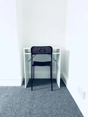 a black chair sitting in front of a desk at Valley Road, Anfield LFC in Liverpool