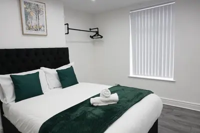 a bedroom with a bed with a towel on it at Central Location Liverpool, Modern Home, 4 BR, Sleeps 9, Free Parking in Liverpool