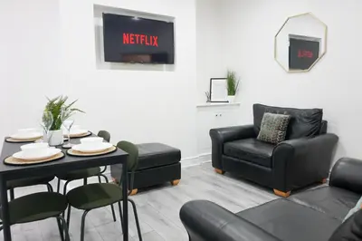 a living room with a table and a chair at Central Location Liverpool, Modern Home, 4 BR, Sleeps 9, Free Parking in Liverpool