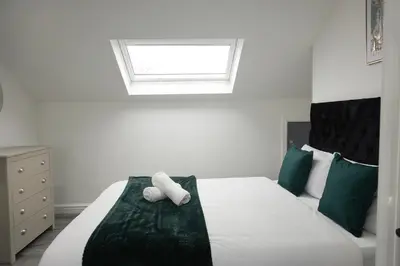 a bedroom with a bed with two white towels on it at Central Location Liverpool, Modern Home, 4 BR, Sleeps 9, Free Parking in Liverpool