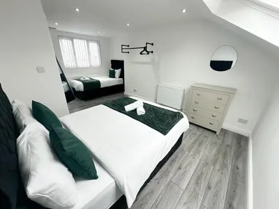 a white bedroom with a bed and a couch at Central Location Liverpool, Modern Home, 4 BR, Sleeps 9, Free Parking in Liverpool