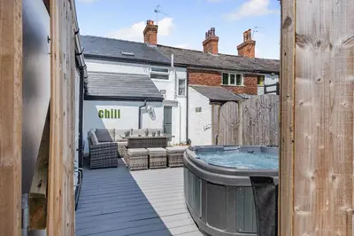 a hot tub on the deck of a house at Botanic Cottages in Southport