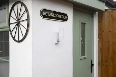 a sign on the side of a building with a door at Botanic Cottages in Southport
