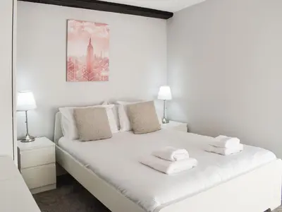 a bedroom with a white bed with towels on it at Beck Cottage in Millom