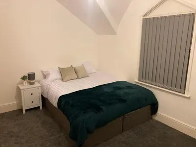 a bedroom with a bed with a green blanket on it at Riverside by Teil in Preston