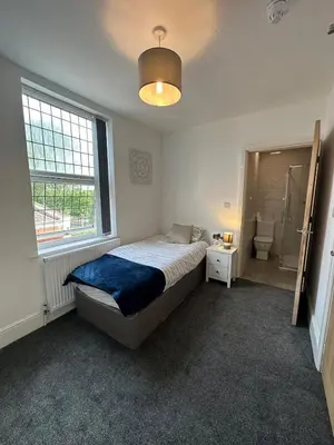 a bedroom with a bed and a window and a bathroom at Riverside by Teil in Preston